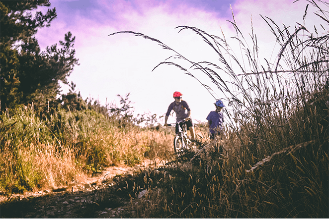 two people mountain biking on trail