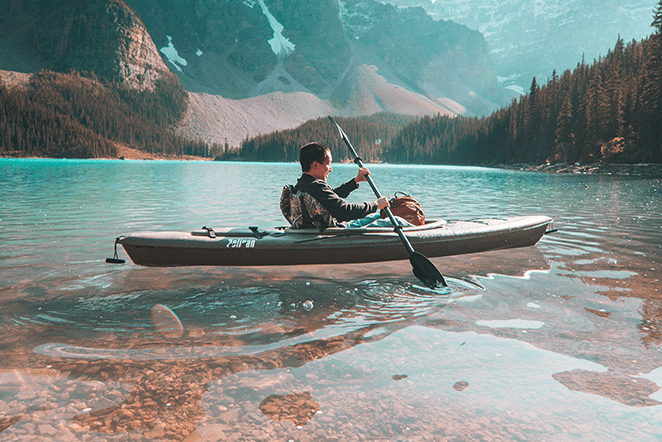 man canoeing in lake